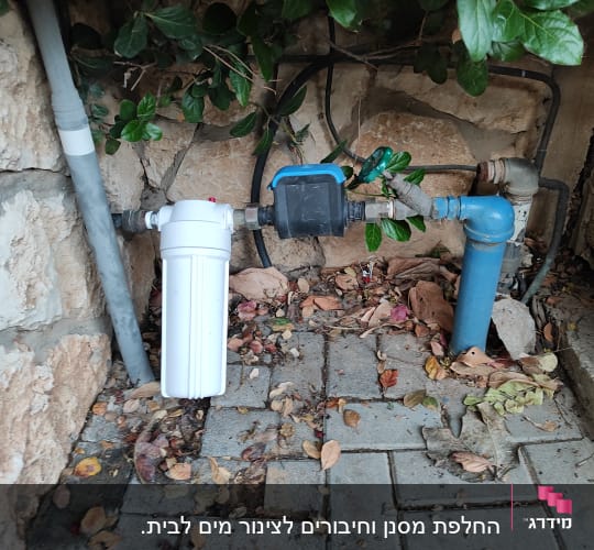 מסנן מים לבן וצינור כחול עם ברז ירוק
